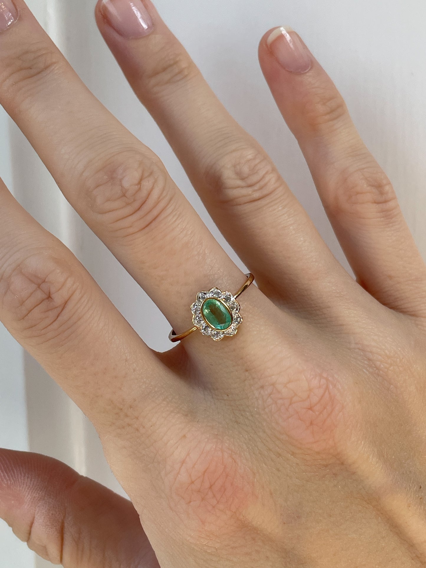 Vintage emerald and diamond halo cluster ring