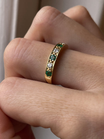 A vintage 1970s emerald and diamond half eternity ring on 18ct gold