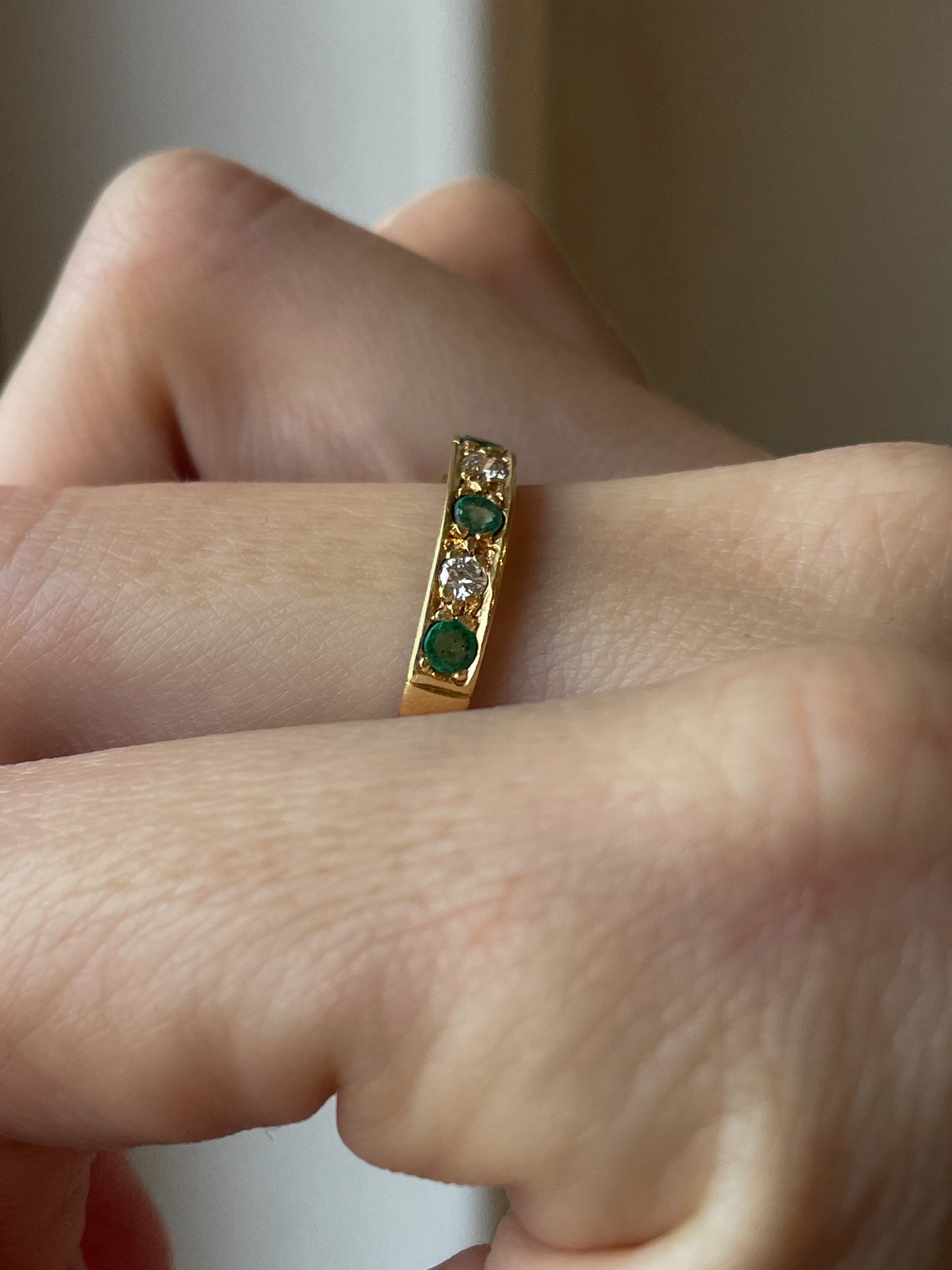 A vintage 1970s emerald and diamond half eternity ring on 18ct gold