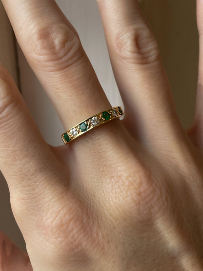 A vintage 1970s emerald and diamond half eternity ring on 18ct gold