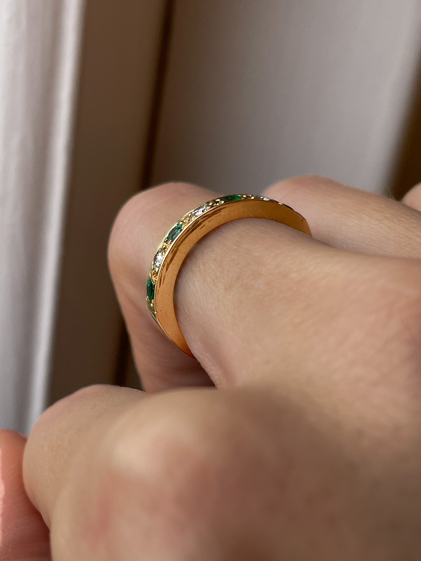 A vintage 1970s emerald and diamond half eternity ring on 18ct gold