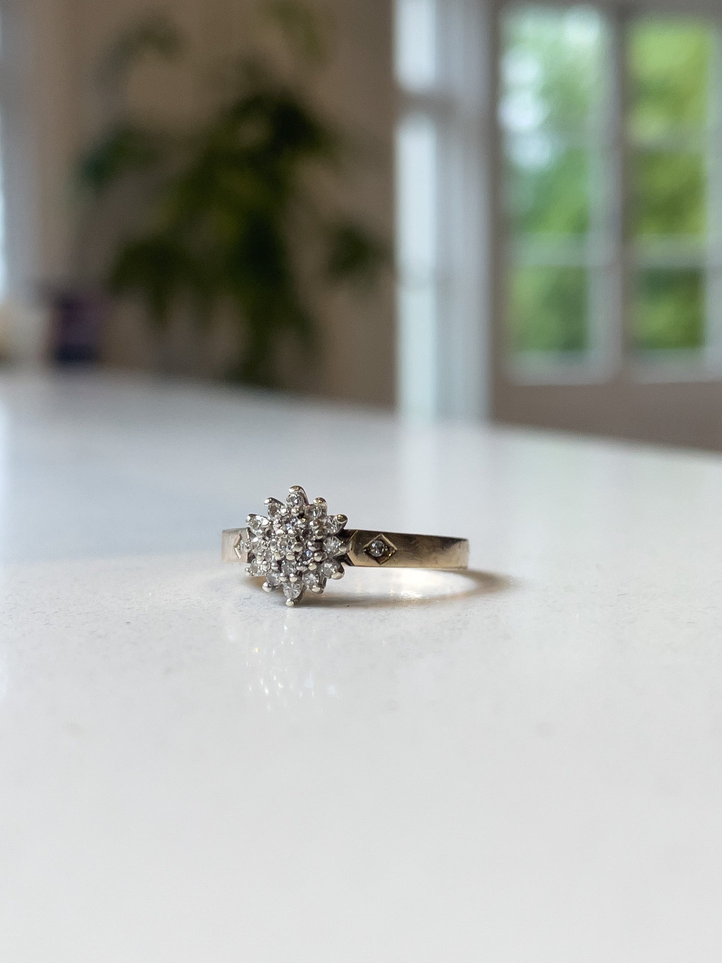 A vintage 9ct gold diamond cluster ring with diamond shoulders