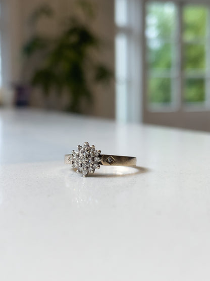 A vintage 9ct gold diamond cluster ring with diamond shoulders