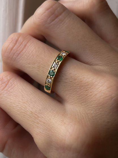 A vintage 1970s emerald and diamond half eternity ring on 18ct gold